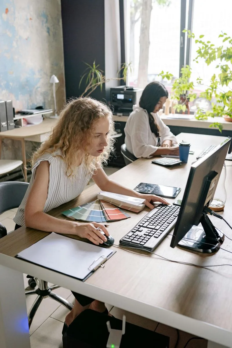 Two colleagues working together at a desk in a small office